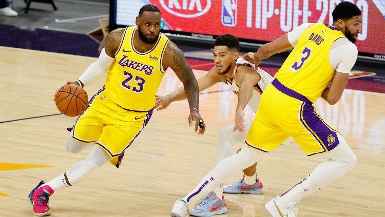LeBron James dan Anthony Davis berjibaku dengan Devin Booker di laga Pramusim NBA antara Phoenix Suns vs LA Lakers, Sabtu (19/12/20). - INDOSPORT