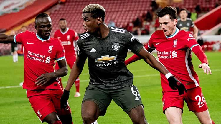 Paul Pogba dari Manchester United bersaing dengan Sadio Mane dan Andrew Robertson dari Liverpool selama pertandingan Liga Premier antara Liverpool dan Manchester United di Anfield pada 17 Januari 2021 di Liverpool,