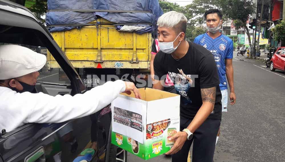 Pemain Arema, Kushedya Hari Yudo dan Jayus Hariono ikut aksi turun ke jalan dalam menggalang dana bantuan bencana di Malang, Minggu (24/01/21).