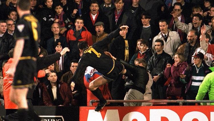 Striker legendaris Manchester United, Eric Cantona, melancarkan tendangan kungfu ke arah suporter Crystal Palace, 25 Januari 1995. - INDOSPORT