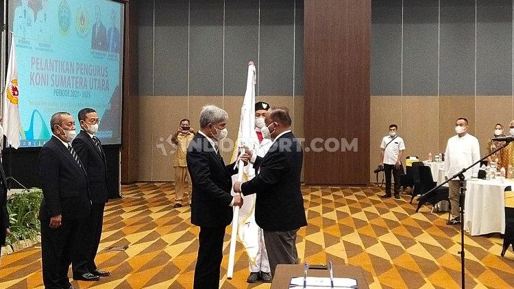 Ketum KONI Pusat, Marciano Norman, saat menyerahkan pataka kepada Ketum KONI Sumut, John Ismadi Lubis, Senin (05/04/21).