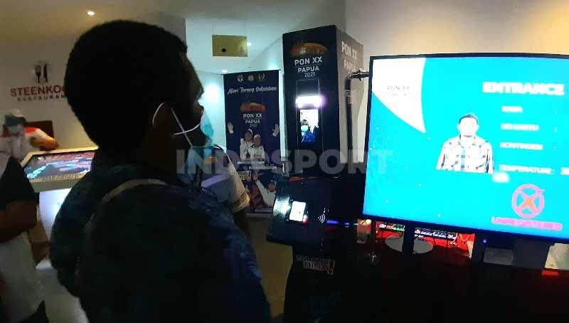 Salah seorang peserta saat melakukan registrasi menggunakan alat scan wajah. - INDOSPORT