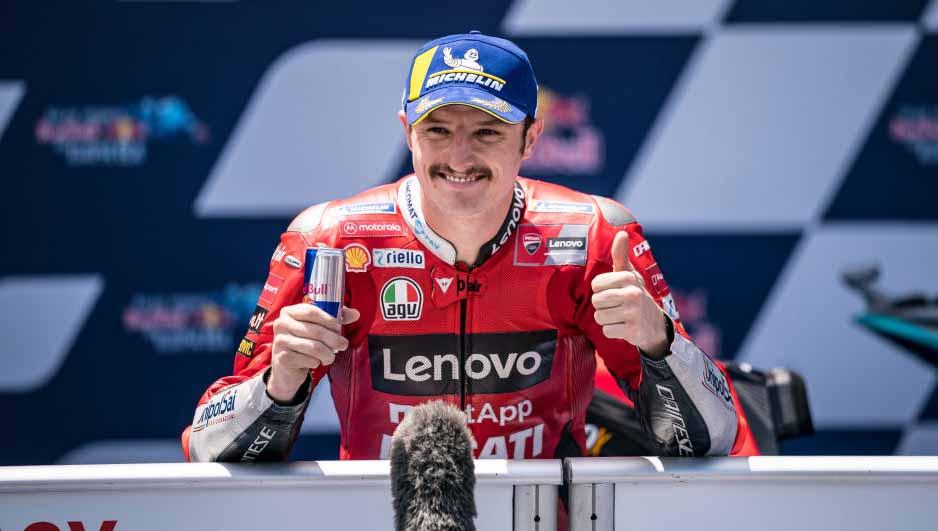 Pembalap asal Australia, Jack Miller, memberikan sarung tangannya pada seorang penggemar setelah ia finis ketiga di MotoGP Jerman pada akhir pekan (19/06/22).