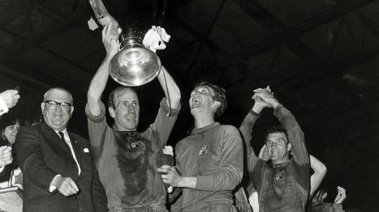 Legenda Manchester United, Bobby Charlton, mengangkat trofi Liga Champions usai mengalahkan Benfica di final, 29 Mei 1968.