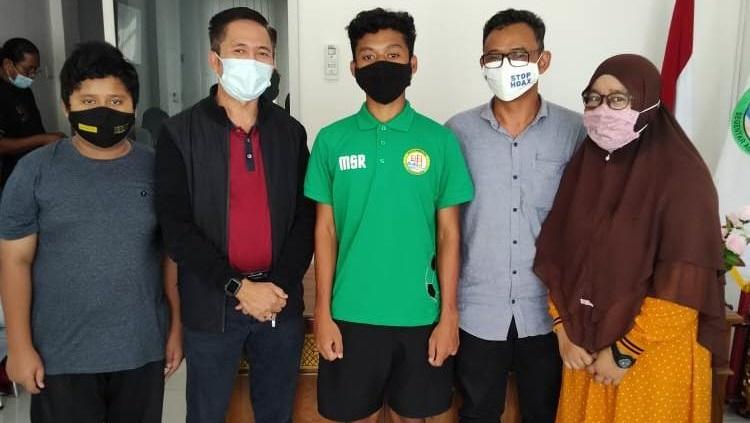 Pemain muda PS Palembang, Sultan Raya, bersama kedua orang tuanya. - INDOSPORT
