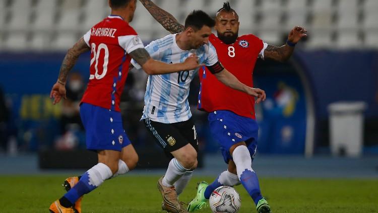 Lionel Messi berduel dengan Arturo Vidal di laga Copa America 2021 Argentina vs Chile. - INDOSPORT