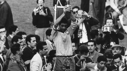 Kapten Brasil, Mauro Ramos, mengangkat trofi Piala Dunia usai mengalahkan Cekoslovakia di final, 17 Juni 1962.