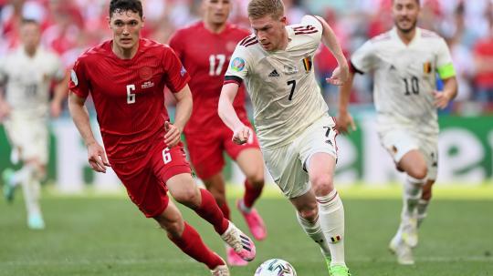 Gelandang Belgia, Kevin De Bruyne (kanan), membawa bola sambil dibayang-bayangi oleh bek Denmark, Andreas Christensen, di laga Grup B Euro 2020.