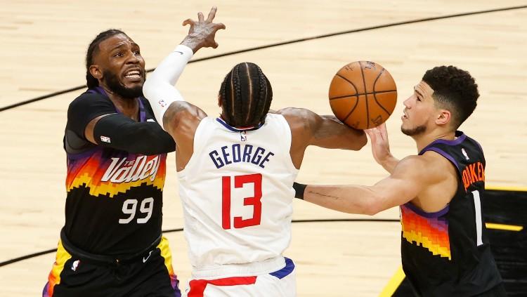 Paul George (tengah) berduel dengan Jae Crowder dan Devin Booker di final wilayah NBA Suns vs Clippers.