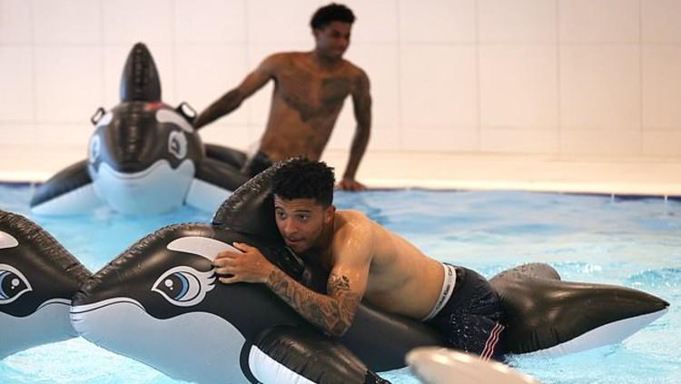 Dua penggawa Timnas Inggris di Euro 2020, Marcus Rashford dan Jadon Sancho menaiki balon pelampung ikan paus pembunuh untuk refreshing