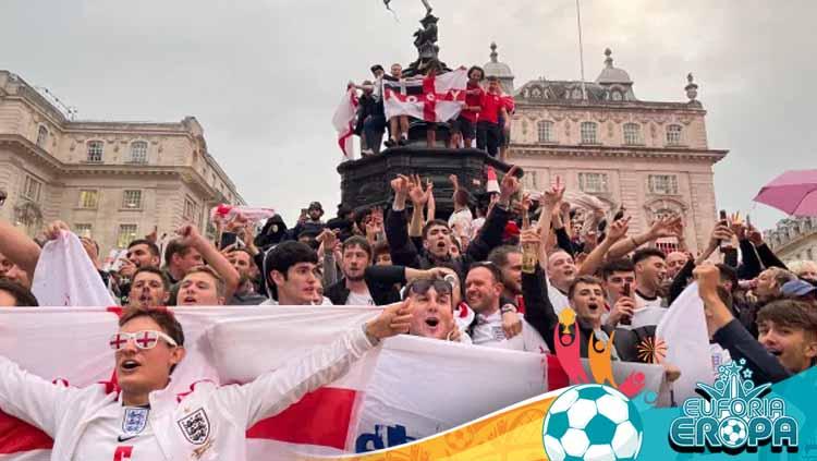 Fans Inggris merayakan kemenangan timnya.