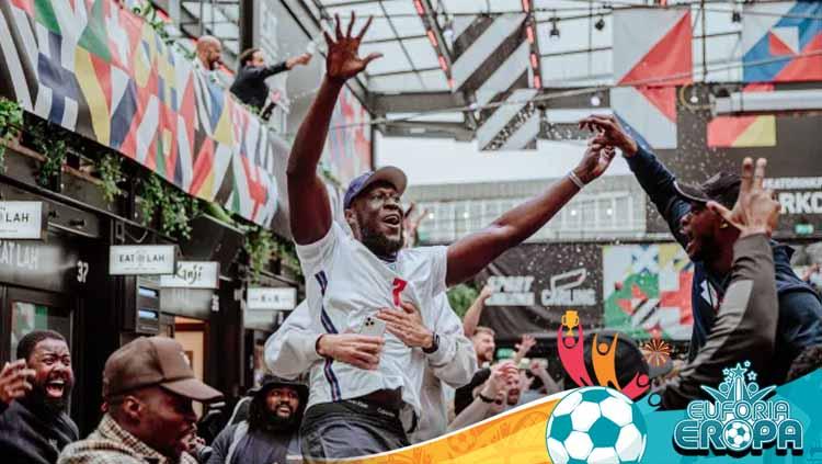 Fans Inggris merayakan kemenangan timnya.