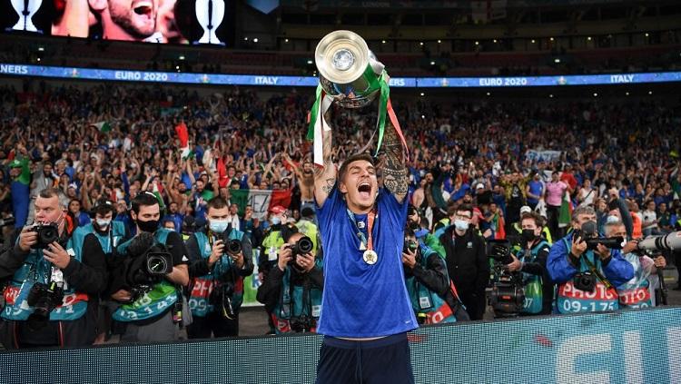 Fullback kanan Italia, Giovanni Di Lorenzo, tengah mengangkat trofi juara Euro 2020.