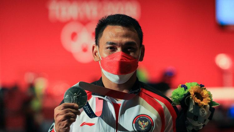 Lifter Indonesia, Eko Yuli saat memperlihatkan medali perak yang ia dapatkan di Olimpiade Tokyo 2020.