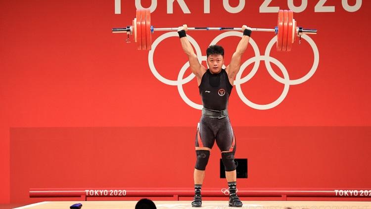 Atlet angkat besi Indonesia, Rahmat Erwin Abdullah saat tampil di Olimpiade Tokyo 2020.