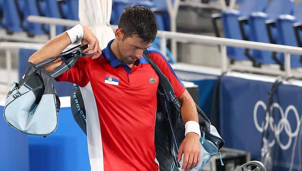 Novak Djokovic asal Serbia meninggalkan lapangan tenis setelah kalah dalam pertandingan semifinal melawan Alexander Zverev dari Jerman. - INDOSPORT