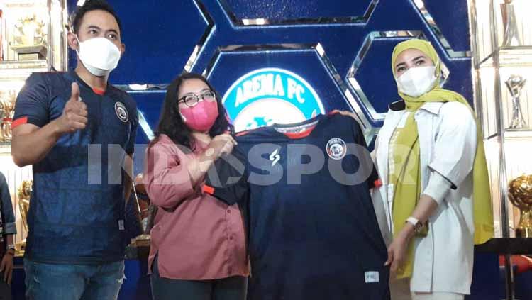 Presiden Arema FC, Gilang Widya Pramana beserta Shandy Purnamasari (istri) secara simbolik membagi jersey untuk awak media. - INDOSPORT