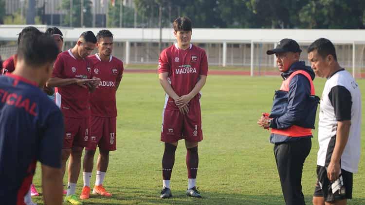 Para penggawa Madura United tengah mendengarkan arahan dari sang pelatih Rahmad Darmawan. - INDOSPORT