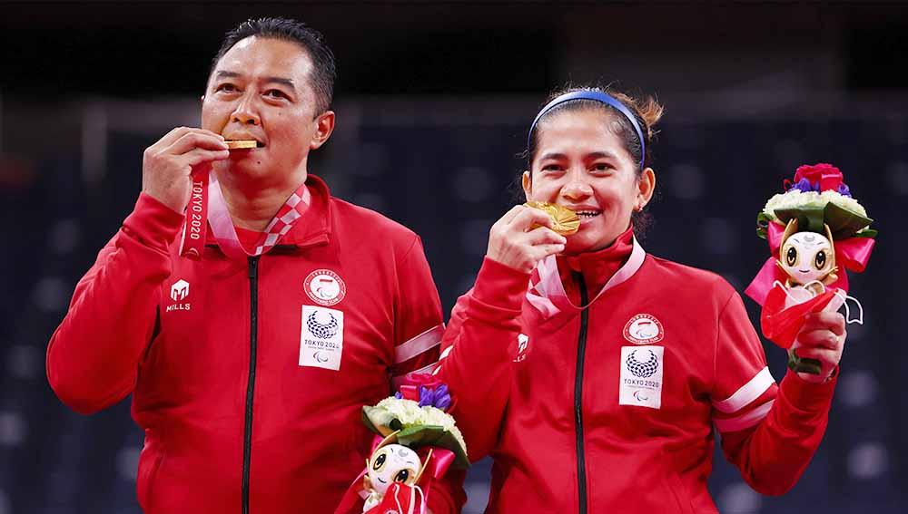 Peraih medali emas Susanto Hary dan Oktila Leani Ratri dari Tim Indonesia berpose di podium untuk Ganda Campuran Paralimpiade Tokyo 2020.