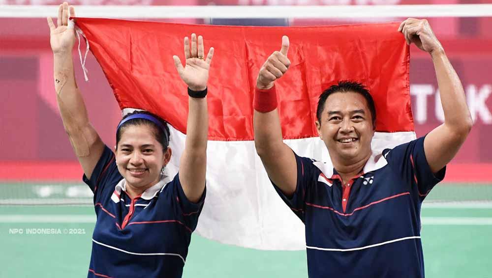 Peraih medali emas Susanto Hary dan Oktila Leani Ratri dari Tim Indonesia berpose di podium untuk Ganda Campuran Paralimpiade Tokyo 2020. - INDOSPORT