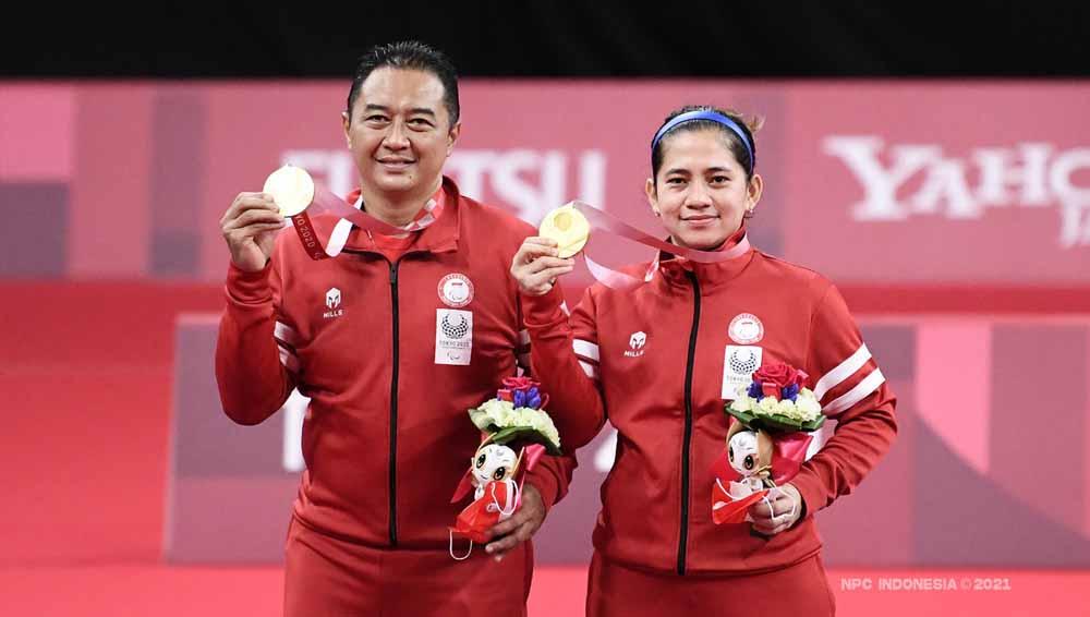 Peraih medali emas Susanto Hary dan Oktila Leani Ratri dari Tim Indonesia berpose di podium untuk Ganda Campuran Paralimpiade Tokyo 2020. - INDOSPORT