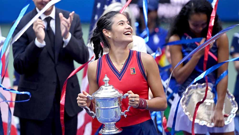 Petenis Inggris Emma Raducanu merayakan dengan trofi usai mengalahkan lawannya Leylah Fernandez asal Kanada turnamen tenis AS Terbuka 2021. - INDOSPORT