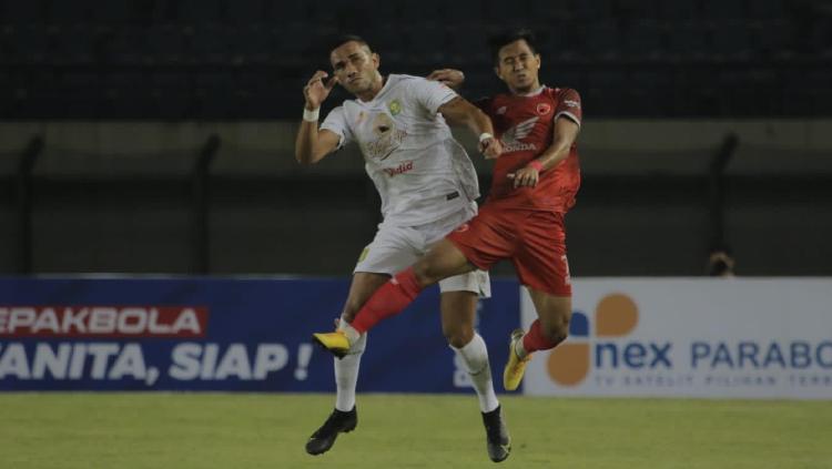 Bek kiri PSM Makassar, Abdul Rachman, berduel dengan pemain Persebaya Surabaya