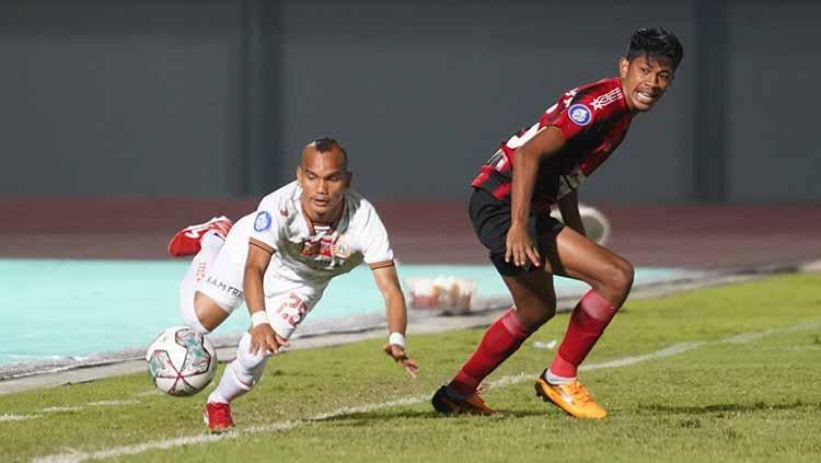 Perjuangan Riko Simanjuntak melewati hadangan lawan pada pertandingan Liga 1 2021/22 antara Persipura vs Persija di Indomilk Arena, Minggu (19/09/21).