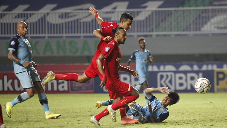 Pemain Persela dijatuhkan dua pemain Persija Rohit Chand dan Otavio Dutra pada laga Liga 1 di Stadion Pakansari, Jumat (24/09/21).