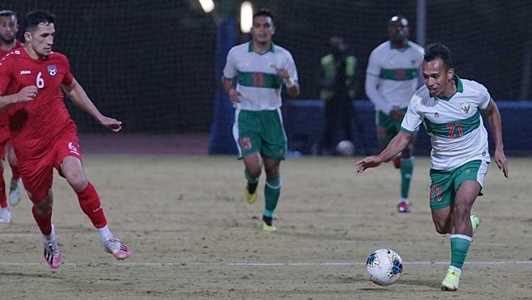 Winger timnas Indonesia, Irfan Jaya, melakukan pengontrolan bola menghadapi pemain Afghanistan - INDOSPORT