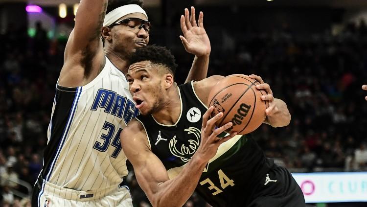 Giannis Antetokounmpo mencoba melewati Wendell Carter di laga NBA Milwaukee Bucks vs Orlando Magic (21/11/21)