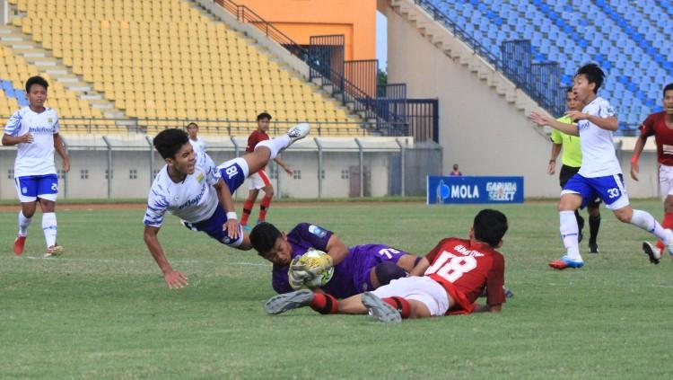 Pemain Persib U-18 terjatuh saat duel dengan kiper Bali United U-18, pada laga final EPA 2021 di Stadion Si Jalak Harupat, Kabupaten Bandung, Kamis (25/11/21). - INDOSPORT