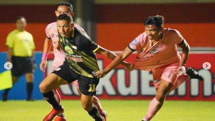 Pemain Barito Putera, Rafinha, saat dikawal dua pemain Madura United dalam pertandingan Liga 1. - INDOSPORT