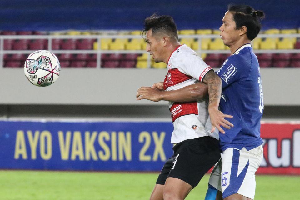 Bek Persib Bandung, Ahmad Jufrianto mengawal ketat pergerakan penyerang Madura United, Silvio Escobar dalam laga pekan ke-15 kompetisi BRI Liga 1 2021/2022 di Stadion Manahan Solo, Sabtu (11/05/21).
