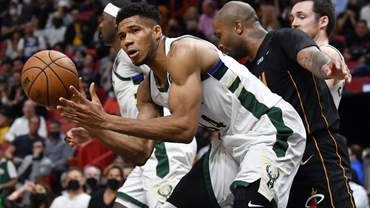 Giannis Antetokounmpo mendapatkan bola rebound di depan P.J Tucker di laga Miami Heat vs Milwaukee Bucks (09/12/21).