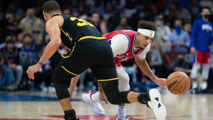 Seth Cury (Sixers) mencoba melewati Stephen Curry (Warriors), Minggu (12/12/21).