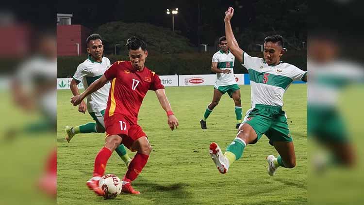 Rizky Ridho menghalau tendangan dari pemain Vietnam pada laga Piala AFF 2020.