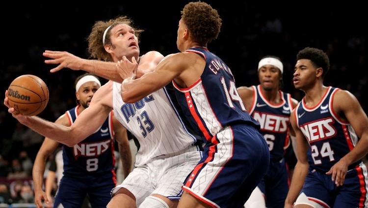 Robin Lopez (Magic) mencoba mengontrol bola dari kawalan Kessler Edwards, David Duke, Cam Thomas dan Patty Mills (Nets).