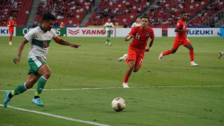 Asnawi Mangkualam tampak lebih kencang larinya dari pemain Singapura untuk merebut bola