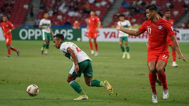 Irfan Jaya berhasil melewati salah satu pemain Singapura pada laga semifinal leg 1 Piala AFF 2020
