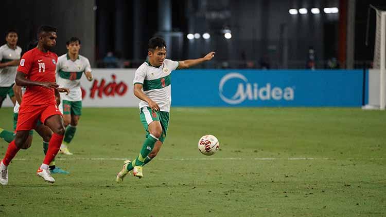 Witan Sulaeman melakukan pengoontrolan bola dari serangan pemain Singapura pada laga Piala AFF 2020 semifinal leg 1