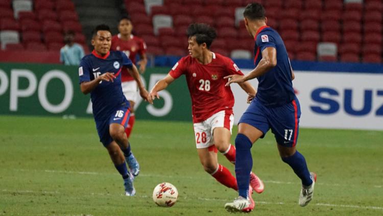 Dua pemain Singapura gendeng ketat Alfeandra Dewangga membawa bola pada laga Piala AFF 2020 Leg kedua. Sabtu (25/12/21).