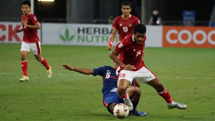 Pemain Singapura tampak berusaha menjegal Ricky Kambuaya untuk merebut bola pada laga Piala AFF 2020 Leg kedua. Sabtu (25/12/21).