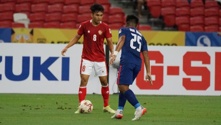 Witan Sulaeman membawa bola untuk melawatu pemain Singapura pada laga Piala AFF 2020 Leg kedua. Sabtu (25/12/21).