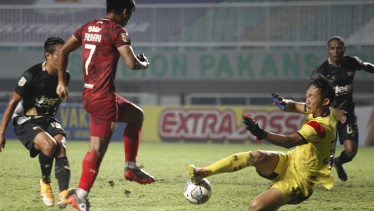 Kiper Dewa United Rivki Mokodompit (kanan) berhasil menggalkan peluang striker Persis Solo Irfan Jauhari pada laga semifinal Liga 2 2021 di Stadion Pakansari, Senin (27/12/21).