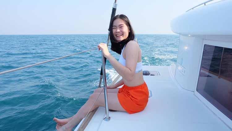 Pebulutangkis cantik Thailand, Busanan Ongbamrungphan, mengunggah momen indah saat dirinya berlibur di atas kapal melintasi Pantai Pattaya. - INDOSPORT