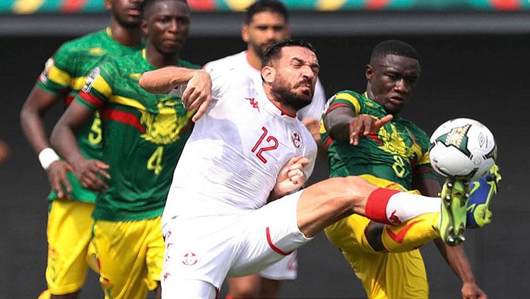 Perebutan bola yang sengit antara kedua pemain di laga Tunisia vs Mali di Piala Afrika 2022. (Twitter.com/CAF_Online) - INDOSPORT