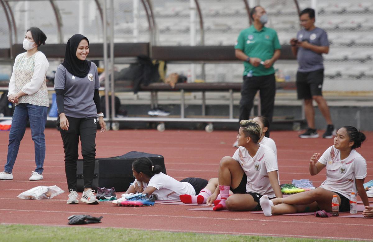 Fisioterapis Timnas Indonesia, Lulu Indah Prawira (kedua kiri) saat bertugas di laga uji coba melawan Persib di Stadion Madya Senayan, Jakarta, Kamis (13/01/22).