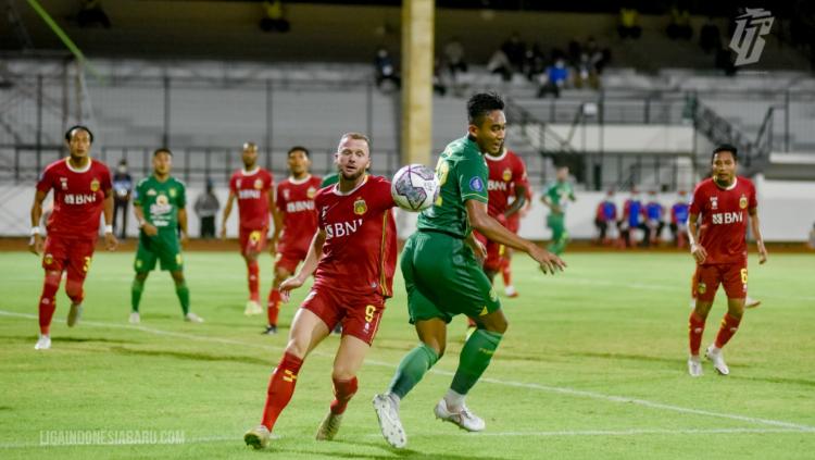 Indosport - Melvin Platje saat berebut bola dengan pemain Persebaya di Liga 1