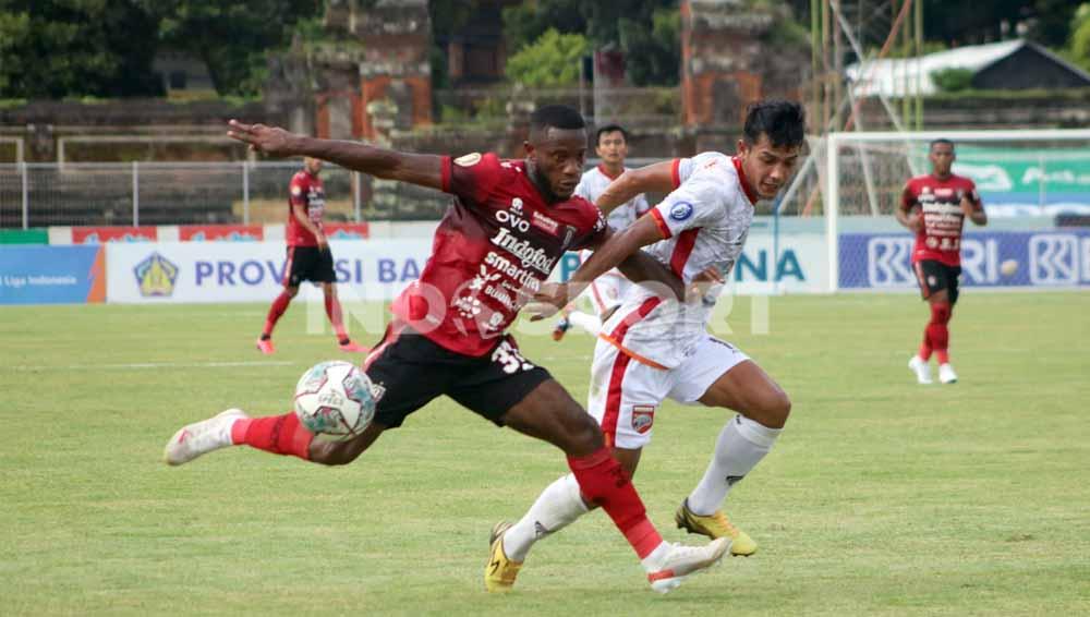 Winger Bali United, Privat Mbarga dikawal bek Borneo FC, Leo Guntara dalam lanjutan BRI Liga 1 2021/2022 di Stadion Ngurah Rai, Denpasar, Sabtu (29/1/22). Foto: Nofik Lukman Hakim/Indosport.com